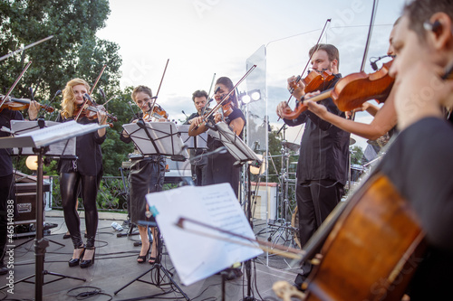 Fotografering Violin players playing classic instrumental music on outdoor stage