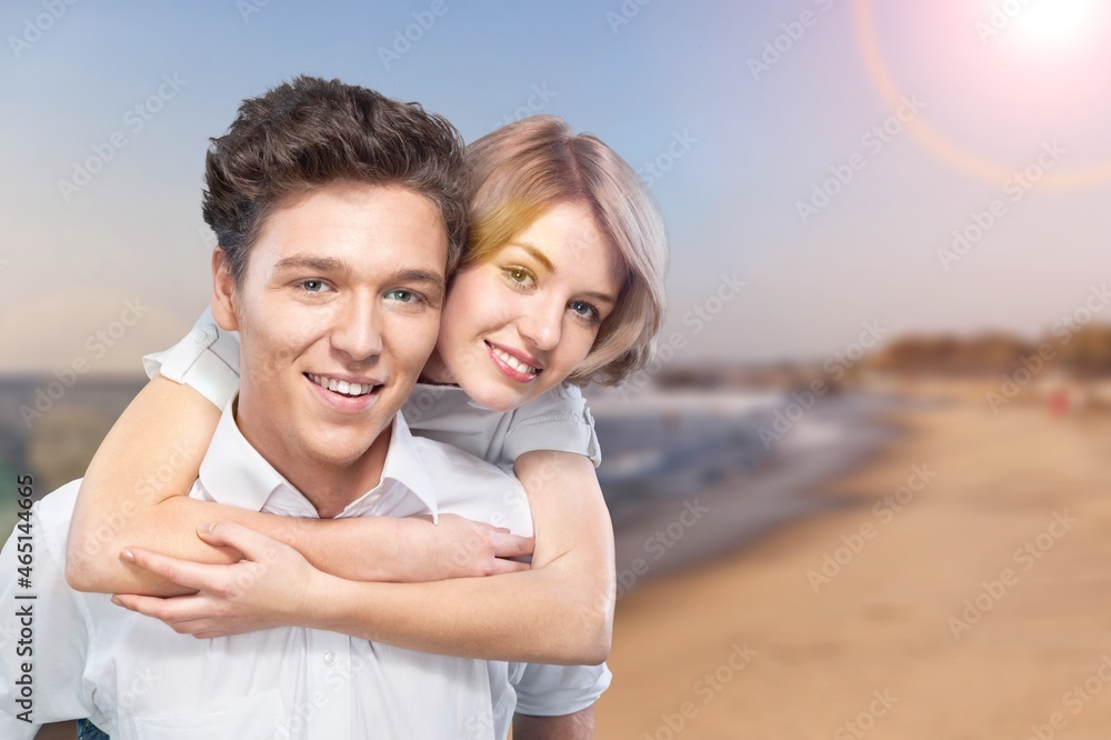 Beautiful woman with a man walking on the beach. Young couple enjoying honeymoon after marriage Beautiful woman with a man walking on the beach. Young couple enjoying honeymoon after marriage