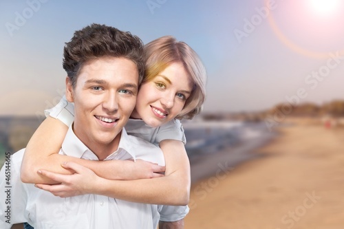 Beautiful woman with a man walking on the beach. Young couple enjoying honeymoon after marriage