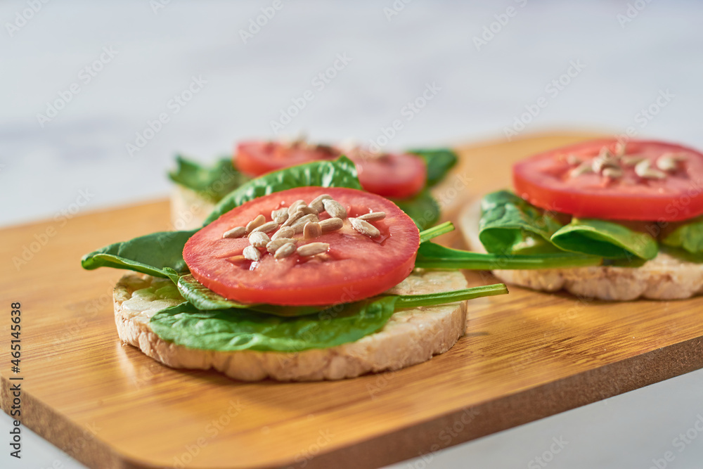Rice cakes with Spinach and tomatoes on top. Healthy food. Rice cakes with Spinach and tomatoes on top. Healthy food.