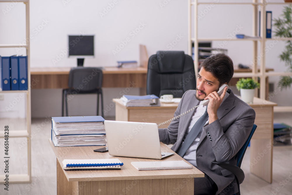 Young male employee working in the office Young male employee working in the office