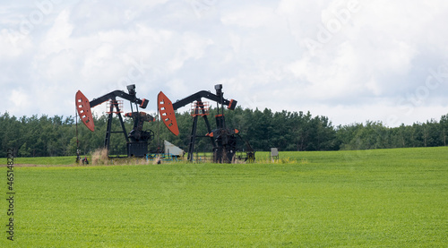 Two oil pumpers in a field. Taken in Alberta, Canada