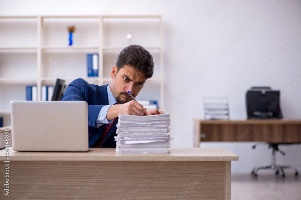 Young businessman employee and too much work in the office Young businessman employee and too much work in the office