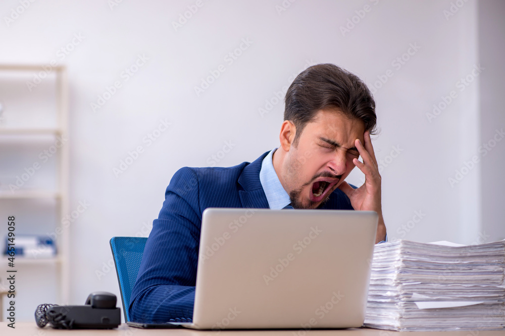 Young businessman employee and too much work in the office Young businessman employee and too much work in the office