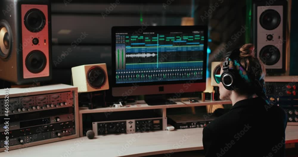Joyful Stylish Woman with Headphones in Sound Studio enjoys listening to Music. Attractive Girl in Sunglasses feeling pleasure from the song. Female Musician. Music Creator. Colorful Record Studio. Joyful Stylish Woman with Headphones in Sound Studio enjoys listening to Music. Attractive Girl in Sunglasses feeling pleasure from the song. Female Musician. Music Creator. Colorful Record Studio.