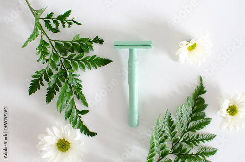 Zero waste green safety razor with eucalyptus and daisies. photo