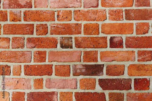 Textured red brick wall background or backdrop, rectangular red terracotta bricks laid out as pattern, architectural structure for old rough building