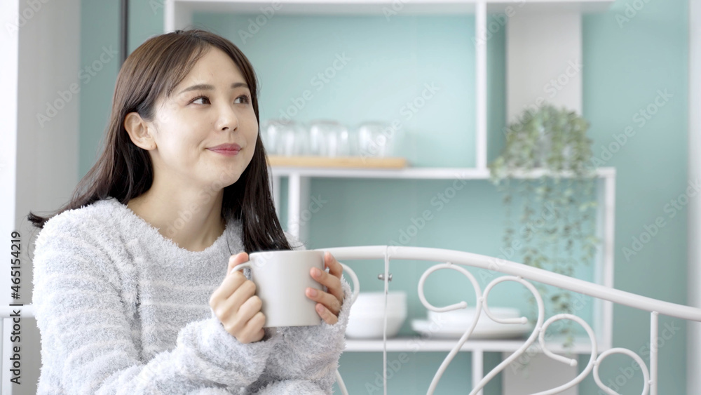 ベッドで飲み物を飲む女性 ベッドで飲み物を飲む女性