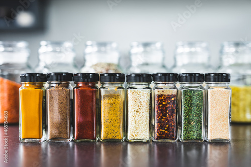 Fototapeta Naklejka Na Ścianę i Meble -  spices and grains in matching spice jars on kitchen counter, simple vegan ingredients and seasonings