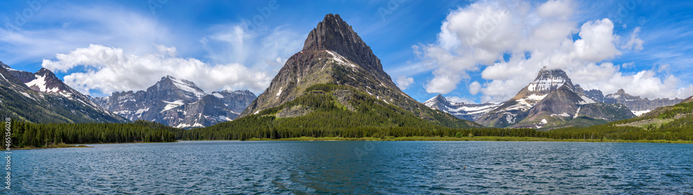 Spring at Swiftcurrent Lake - A panoramic view of Swiftcurrent Lake, with rugged mountain peaks towering at west shore, on a sunny Spring morning. Many Glacier, Glacier National Park, Montana, USA.