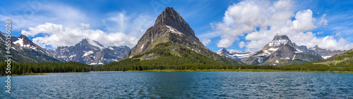 Spring at Swiftcurrent Lake - A panoramic view of Swiftcurrent Lake, with rugged mountain peaks towering at west shore, on a sunny Spring morning. Many Glacier, Glacier National Park, Montana, USA. photo