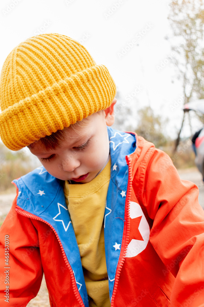 Boy in an orange jacket rides a balance bike in the autumn forest. Copy space Boy in an orange jacket rides a balance bike in the autumn forest. Copy space