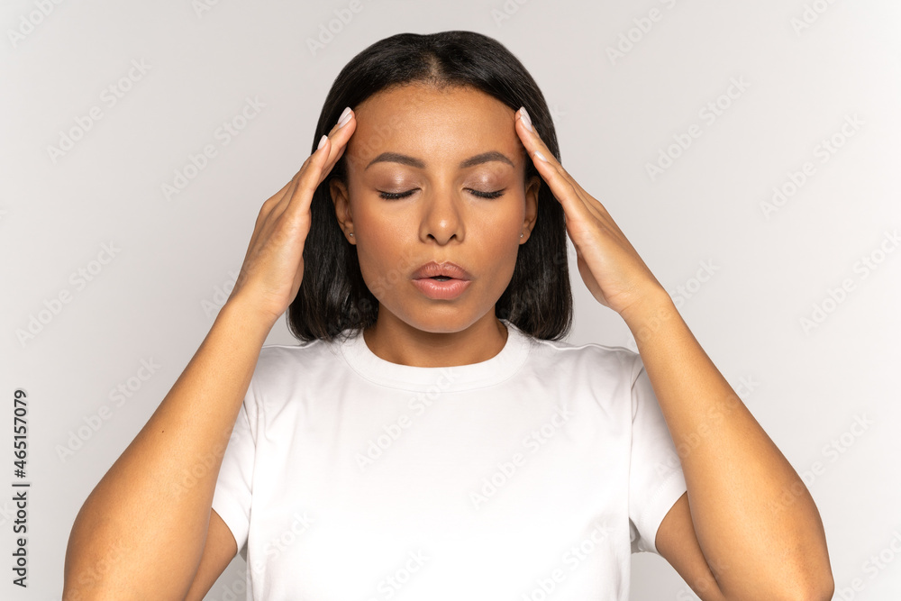 Stressed young woman massaging temples and breathing in deeply to relief from emotional stress, anxiety or disorder. Anxious female with closed eyes touching head suffer from hard headache or migraine - obrazy, fototapety, plakaty 