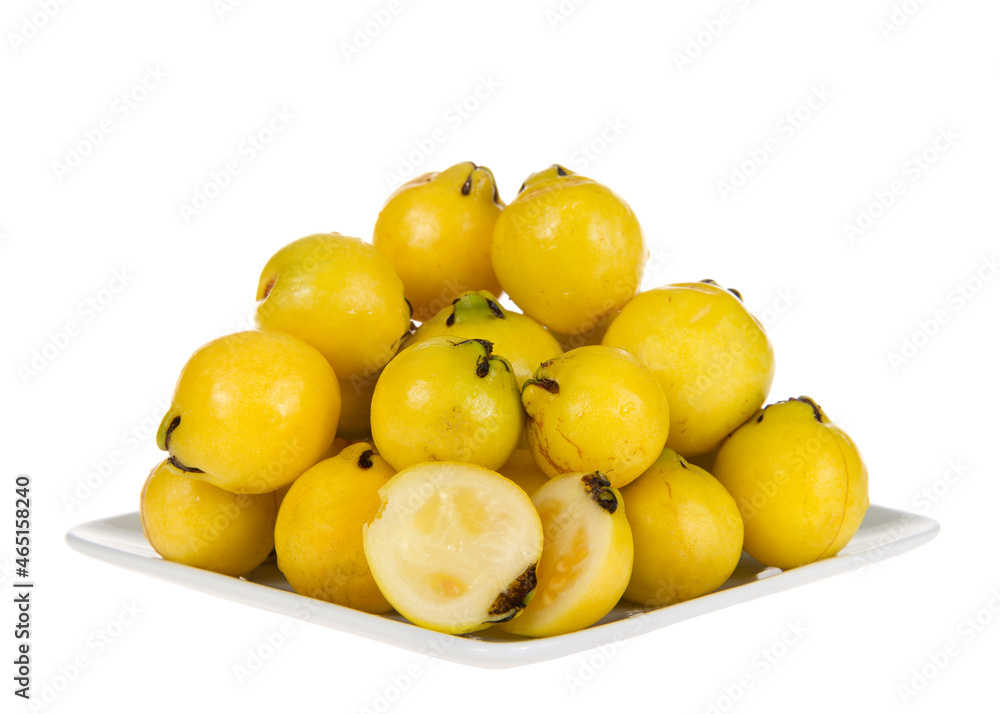 Small square porcelain plate piled high with fresh ripe lemon guava fruit, isolated on white. One fruit sliced in half on front of plate. Small square porcelain plate piled high with fresh ripe lemon guava fruit, isolated on white. One fruit sliced in half on front of plate.