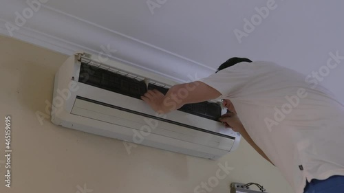 Man removing dusty air conditioner filters. Home cleaning and maintenance concept. photo