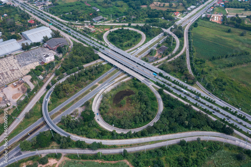 Aerial view of highway junctions with roundabout. Bridge roads shape circle in structure of architecture and transportation concept. Top view. Urban city, Bangkok at sunset, Thailand