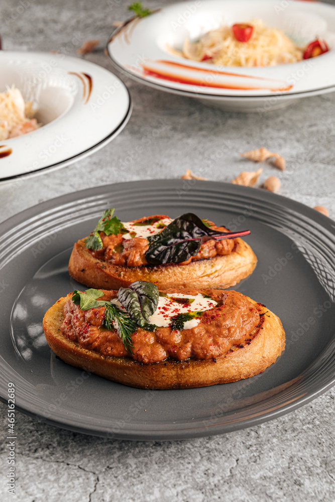 Two delicious bruschettas with eggplant aubergine spread on a plate