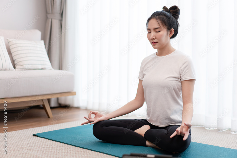 Productive activity concept a calm girl concentrating on meditating alone among peaceful atmosphere in the living room Productive activity concept a calm girl concentrating on meditating alone among peaceful atmosphere in the living room