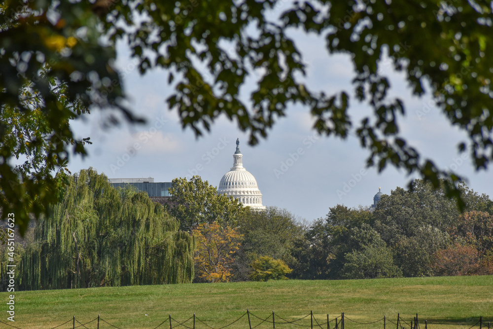 Washington, DC, USA - October 25, 2021: U.S. Capitol Building as Seen from Henry Bacon Drive, Near the Vietnam Veterans Memorial, Framed by Trees and Leaves in the Foreground on a Sunny Fall Day