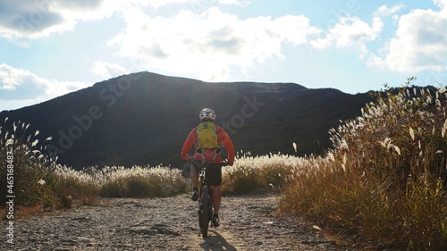 A person cycling with Mt. Cheonwang in Miryang, Korea photo