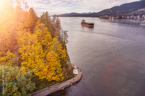 Aerial View of Seawall in Stanley park and Container Ship. Sunset Art Render. Taken from Lions Gate Bridge, British Columbia, Canada. Modern City on West Coast