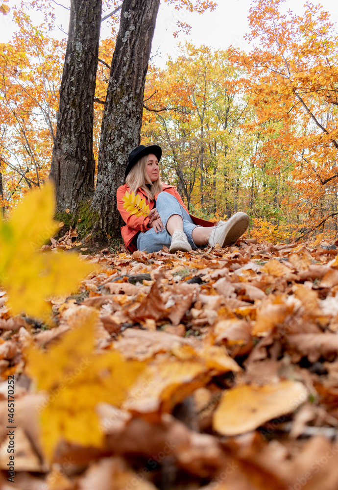 Young girl with blond hair walks in the autumn forest. Wellness concept. Young girl with blond hair walks in the autumn forest. Wellness concept.