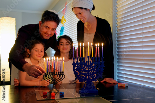 Fotografiet Family kindling candles on the eight day of Hanukkah Jewish holiday festival