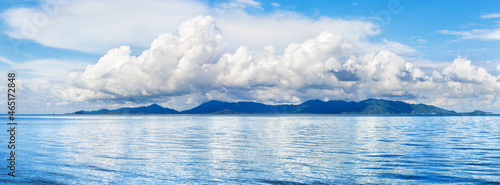Koh Phangan wide panoramic view from Koh Samui, Thailand. Beautiful tropical island landscape, blue sea water waves, sunny sky, white cumulus clouds, summer holidays vacation travel, seascape panorama