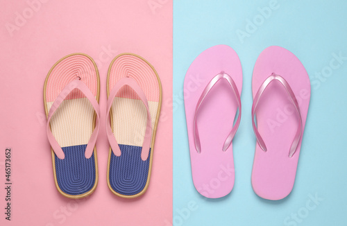 Colored flip flops on blue pink pastel background