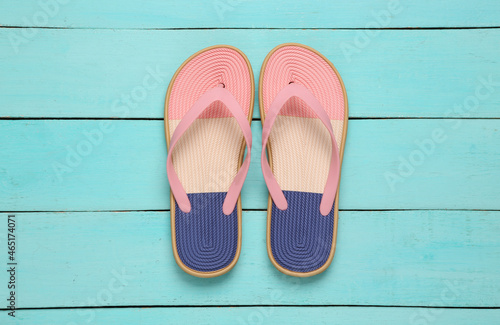 Colored flip flops on blue wooden background. Top view