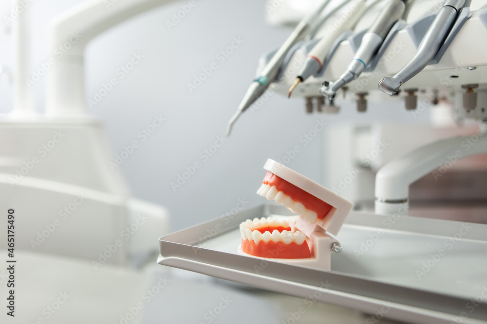 Human jaw model with dental tools drill in a dental clinic. Medicine, health, stomatology concept. Human jaw model with dental tools drill in a dental clinic. Medicine, health, stomatology concept.