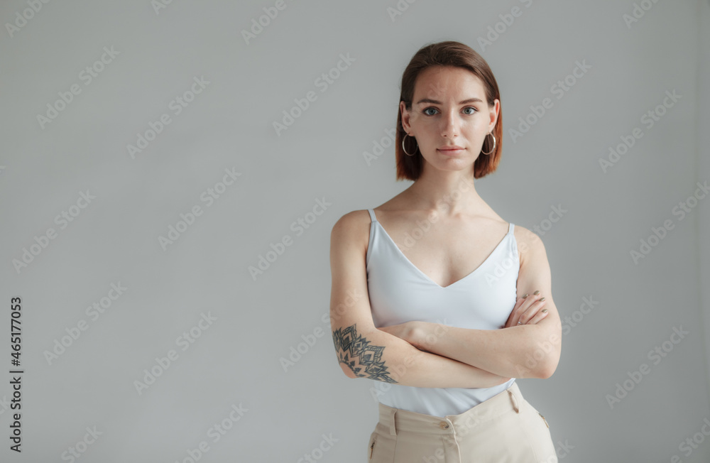 Obraz premium Portrait of self-styled stylish modern woman with short hair on gray background