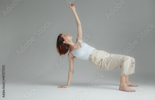 Young stylish woman dancing contempo on gray background. Charisma and grace