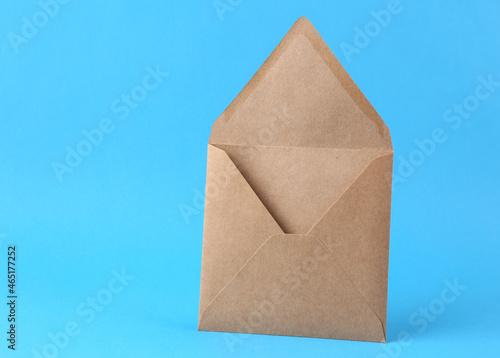 Open blank craft envelope on blue background