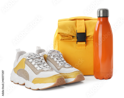 Stylish shoes, backpack and bottle of water on white background