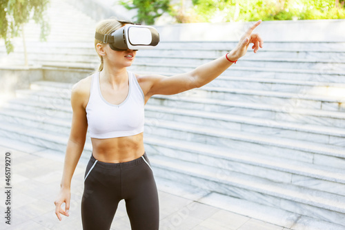 Fitness woman with virtual reality helmet outdoors © splitov27