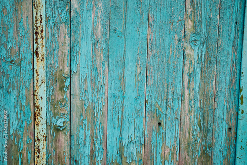 An old wooden wall with peeling paint. Beautiful textured background.