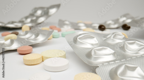 MACRO: Many of pills and opened blisters on a white background