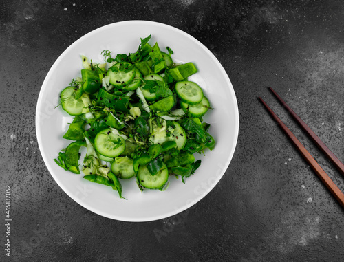 salad with cucumbers and herbs on a dark background