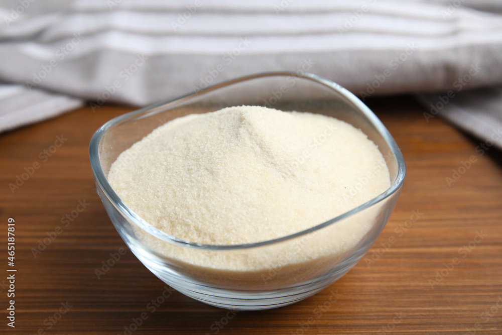 Gelatin powder in glass bowl on wooden table, closeup Gelatin powder in glass bowl on wooden table, closeup