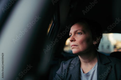 Quadro su tela Worried businesswoman waiting in the car and looking out the window