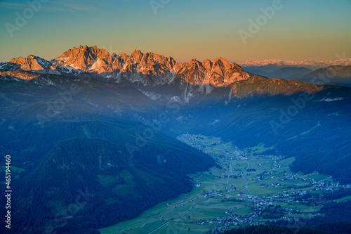 Idyllic view of houses amidst mountains during sunset photo