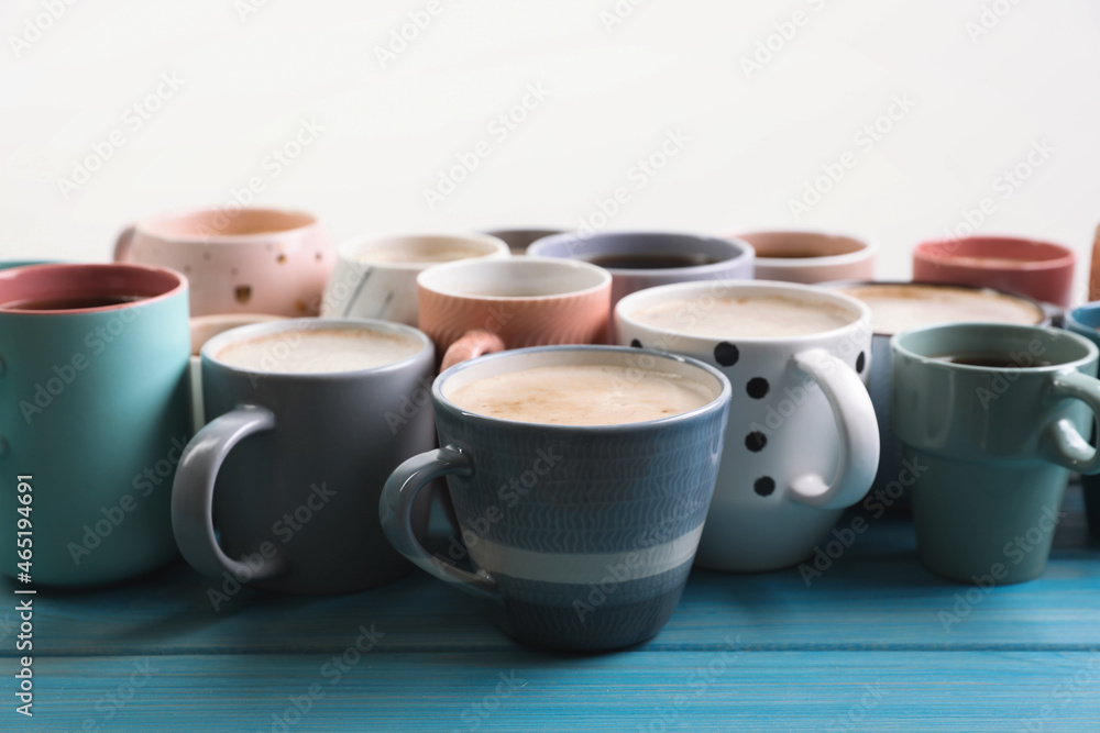 Many cups of different coffee drinks on light blue wooden table Many cups of different coffee drinks on light blue wooden table