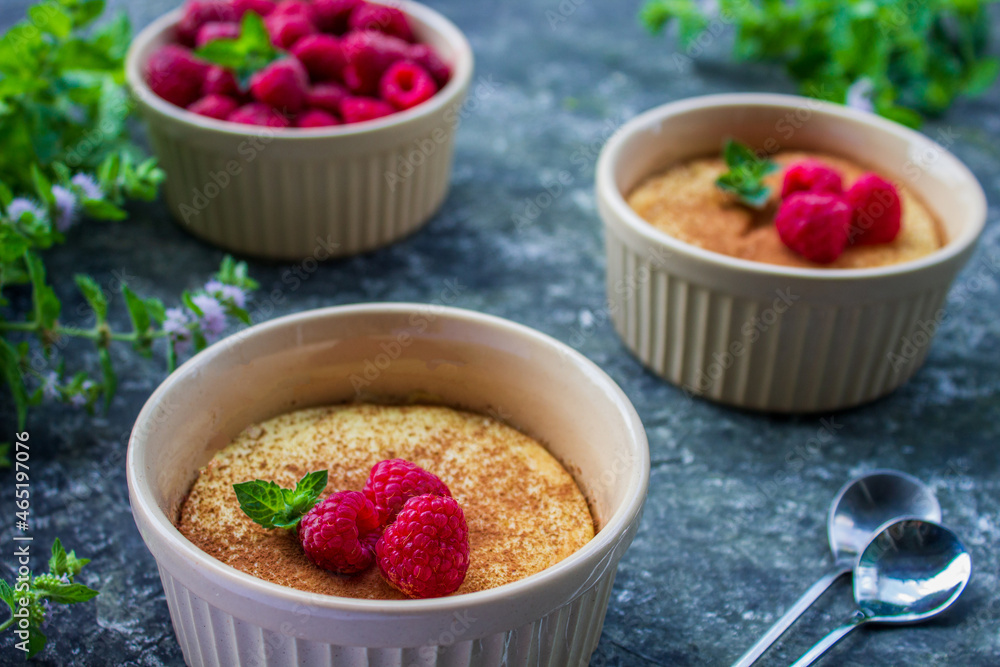 Cheese soufflé with raspberries on a dark background, close-up, simple composition Cheese soufflé with raspberries on a dark background, close-up, simple composition