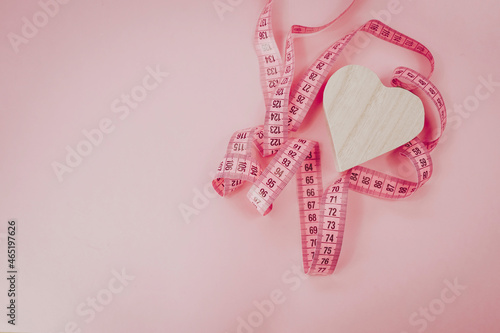 Measure tape on the pastel pink background. Mock up for body slimming, weight loss or dressmaker's offer or other ideas. Empty place for text, logo or object