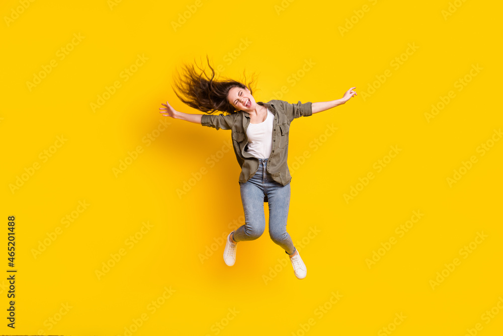 Full length body size view of attractive cheerful girl jumping having fun isolated over bright yellow color background