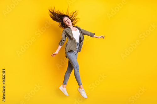 Full body profile photo of crazy cheerful lady flying hair open mouth look camera isolated on yellow color background