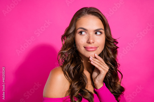 Portrait of attractive minded wavy-haired girl touching chin thinking copy space isolated over bright pink color background