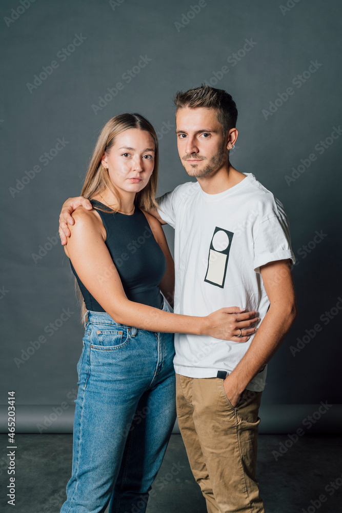 Young couple embracing while standing in studio Young couple embracing while standing in studio