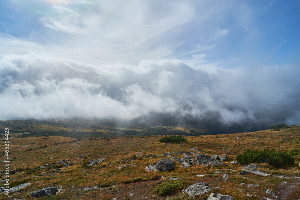 Amazing clouds in the mountains. View of the clouds from the top of the mountain. Wild nature background
